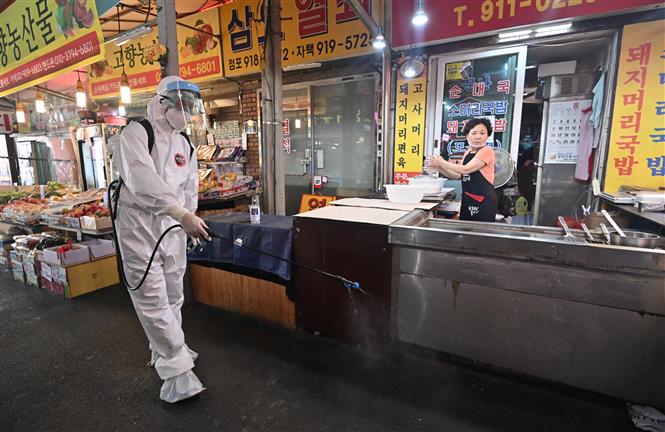 Nhân viên y tế phun thuốc khử trùng nhằm ngăn dịch COVID-19 lây lan tại khu chợ ở Seoul ngày 18-8-2020. Ảnh: AFP/TTXVN