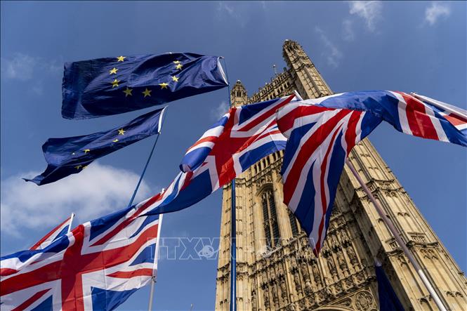 Quốc kỳ Anh (dưới) và cờ Liên minh châu Âu (EU) bên ngoài tòa nhà Quốc hội Anh ở Westminster, London. Ảnh: AFP/TTXVN