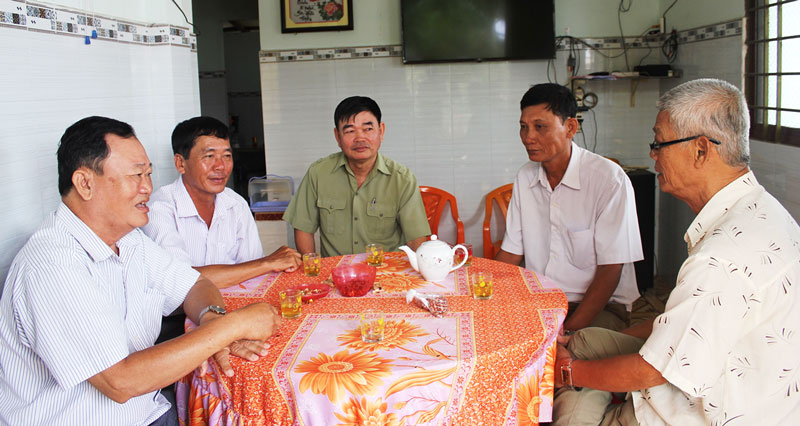 Ðiển hình trong thi đua xây nông thôn mới Ông Đào Văn Hội (bên trái) trao đổi với Ban vận động ấp của xã Bình Thành về thực hiện các tiêu chí nông thôn mới nâng cao. Ảnh: Hoàng Trung