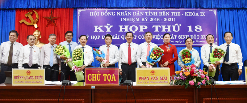 Chủ tịch HDND tỉnh Phan Văn Mãi trao hoa chúc mừng tại kỳ họp.