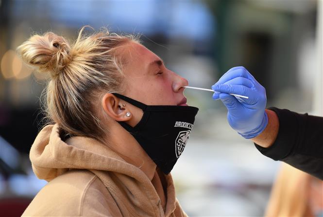 Nhân viên y tế lấy mẫu xét nghiệm COVID-19 tại New York, Mỹ. Ảnh: AFP/TTXVN