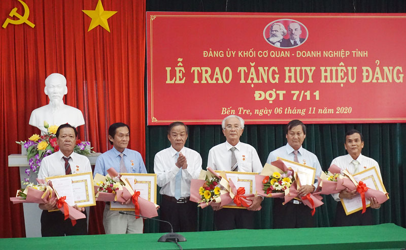 Bí thư Đảng ủy Khối Cơ quan - Doanh nghiệp tỉnh trao Huy hiệu Đảng, hoa cho các đảng viên đủ niên hạn 30 năm tuổi Đảng.