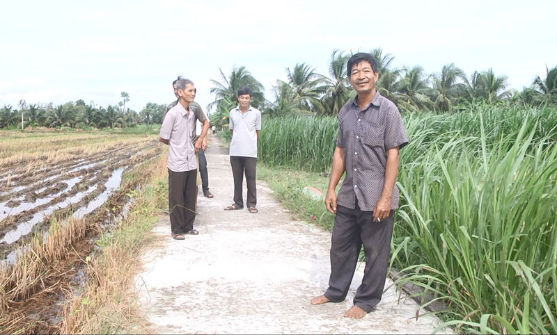 Ông Phạm Văn Nhựt tích cực hiến đất làm đường Ông Phạm Văn Nhựt (phải) vui mừng đứng trên đường vừa mới được bê-tông có sự đóng góp của mình.