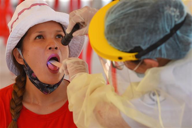 Thế giới trên 1,5 triệu người tử vong; Mỹ liên tiếp phá kỷ lục buồn Người dân Indonesia đeo khẩu trang phòng dịch COVID-19. Ảnh: Strait Times