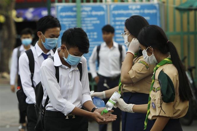 Thế giới trên 1,5 triệu người tử vong; Mỹ liên tiếp phá kỷ lục buồn Các học sinh tiến hành sát khuẩn tay nhằm ngăn dịch COVID-19 lây lan, trước khi vào lớp ở Phnom Penh, Campuchia, ngày 2-11-2020. Ảnh: AFP/TTXVN