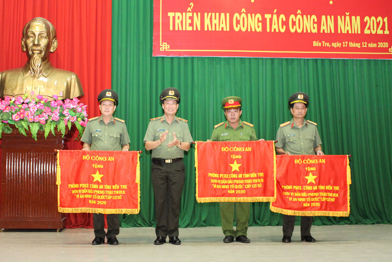 Thiếu tướng Lê Tấn Tới - Thứ trưởng Bộ Công an trao cờ thi đua của Bộ Công an cho các tập thể.