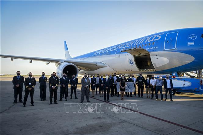 Nhà chức trách cùng phi hành đoàn chụp ảnh lưu niệm bên máy bay thuộc hãng hàng không quốc gia Aerolineas Argentinas của Argentina tại sân bay quốc tế Sheremetyevo, gần Moskva, Nga trước khi máy bay này chở lô vaccine Sputnik V ngừa bệnh COVID-19 đầu tiên về nước ngày 23-12-2020. Ảnh: AFP/TTXVN