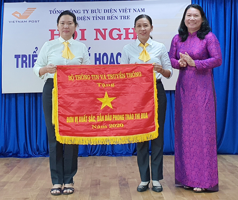 Phó chủ tịch UBND tỉnh Nguyễn Thị Bé Mười trao cờ thi đua cho đơn vị Bưu điện huyện Chợ Lách.