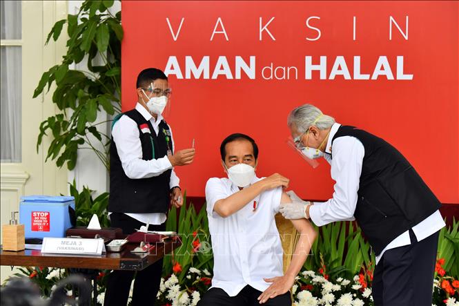 Thế giới thêm 15.194 ca tử vong, biến thể mới lan ra 50 nước và vùng lãnh thổ Tổng thống Indonesia Joko Widodo (giữa) được tiêm vaccine ngừa COVID-19 tại Jakarta, Indonesia ngày 13-1-2021. Ảnh: AFP/TTXVN