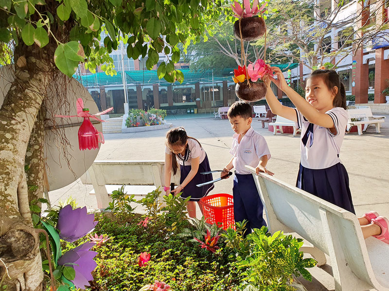 Học sinh Trường Tiểu học Chu Văn An chăm sóc bồn hoa trong khuôn viên trường.