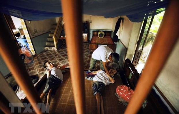 Pháp sắp xét xử vụ kiện chất độc da cam trong Chiến tranh Việt Nam Ông Lại Văn Biên (huyện Vũ Thư, Thái Bình) chăm sóc cho hai con trai bị ảnh hưởng bởi chất độc da cam. (Ảnh: TTXVN)