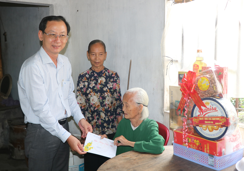 Phó chủ tịch UBND Nguyễn Minh Cảnh thăm cụ Đinh Thị Mỹ, xã Tân Hội. Ảnh: T. Thảo