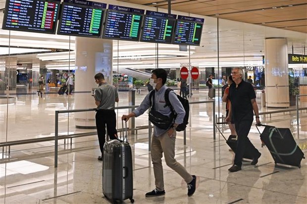 Hành khách tại sân bay quốc tế Changi ở Singapore ngày 16-3-2020. (Nguồn: AFP/TTXVN)