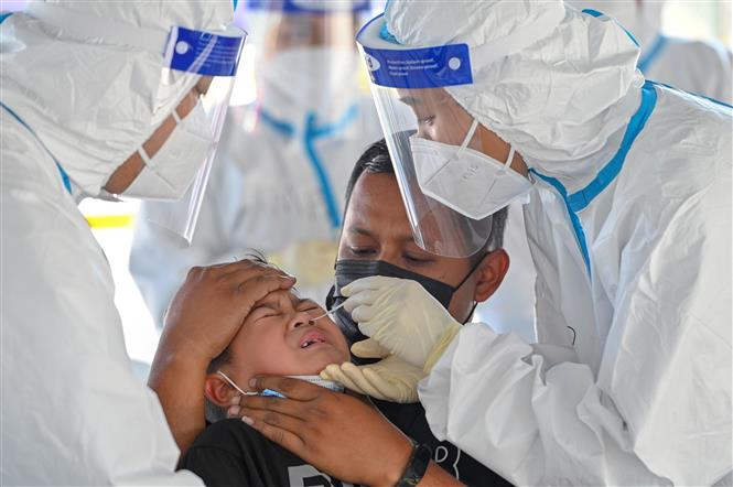 Nhân viên y tế lấy mẫu xét nghiệm COVID-19 cho trẻ em tại Petaling Jaya, bang Selangor, Malaysia, ngày 21-2-2021. Ảnh: THX/ TTXVN