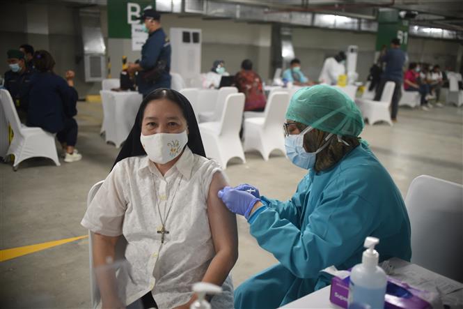 Thế giới trên 2,5 triệu ca tử vong, Hội đồng Bảo an ra nghị quyết vaccine công bằng Nhân viên y tế tiêm vaccine phòng COVID-19 cho người dân tại Jakarta, Indonesia, ngày 24-2-2021. Ảnh: THX/ TTXVN