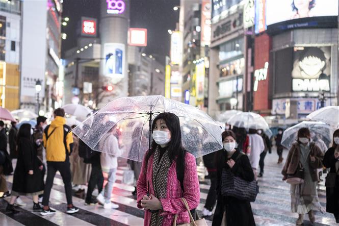 Người dân đeo khẩu trang phòng dịch COVID-19 khi di chuyển trên đường phố ở Tokyo, Nhật Bản ngày 5-3-2021. Ảnh: AFP/TTXVN