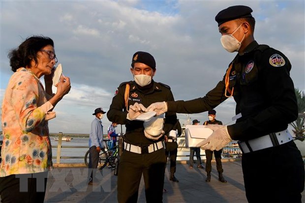 Cảnh sát phát khẩu trang miễn phí cho người dân tại Phnom Penh, Campuchia. Ảnh: AFP/TTXVN