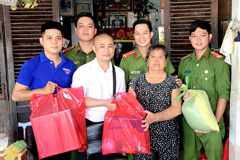 Đại úy Trọng (đứng giữa, hàng sau) trong một lần đến thăm và tặng quà cho gia đình chính sách ở xã Thới Thuận (Bình Đại) vào cuối năm 2020.