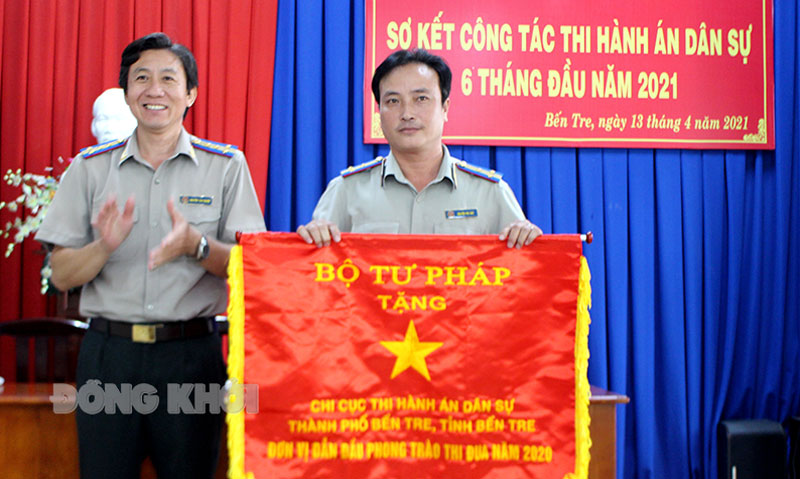 Cục trưởng Cục Thi hành án dân sự tỉnh Nguyễn Văn Nghiệp trao cờ thi đua xuất sắc của Bộ Tư pháp cho Chi cục Thi hành án dân sự TP. Bến Tre.