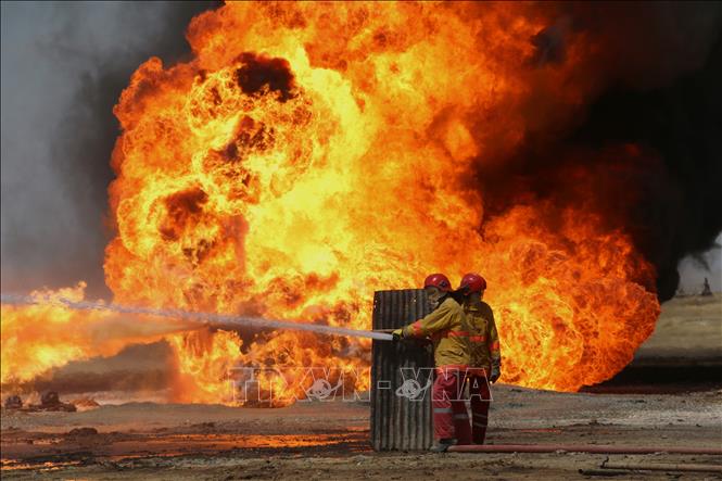 Nhân viên cứu hỏa Iraq nỗ lực khống chế đám cháy tại mỏ dầu Khabbaz sau vụ tấn công do các phần tử khủng bố IS tiến hành ngày 1-6-2016. Ảnh tư liệu: AFP/TTXVN