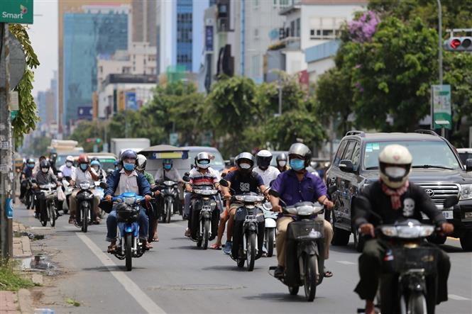 Thế giới gần 3,3 triệu người tử vong; Biến chủng Ấn Độ đáng quan ngại cấp toàn cầu Người dân Phnom Penh tham gia giao thông bình thường tại khu vực được phép di chuyển sau khi thành phố dỡ bỏ lệnh phong tỏa. Ảnh: Nguyễn Vũ Hùng - PV TTXVN tại Campuchia