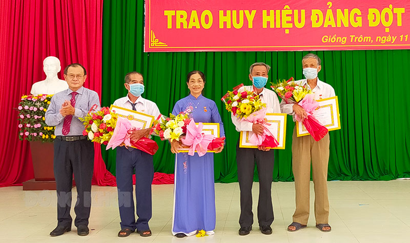 Phó chủ tịch Thường trực HĐND tỉnh Huỳnh Quang Triệu trao huy hiệu đảng cho đảng viên.