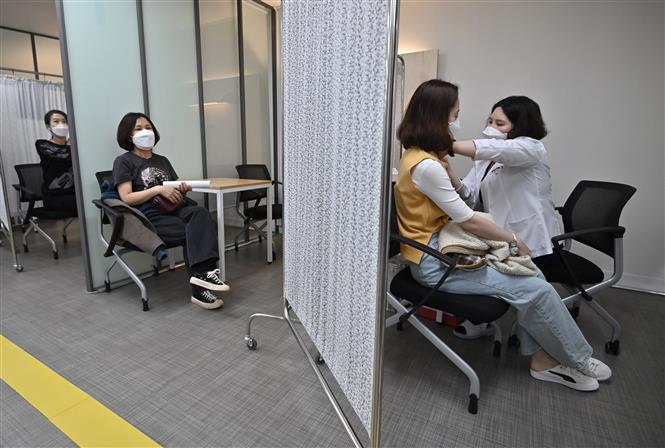 Nhân viên y tế tiêm vaccine phòng COVID cho người dân tại Seoul, Hàn Quốc, ngày 20-3-2021. Ảnh: AFP/TTXVN