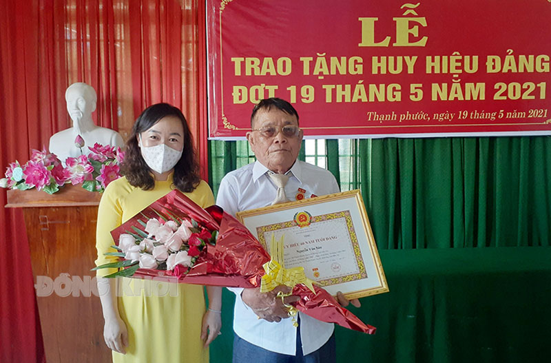 Phó Bí thư Thường trực Huyện ủy Bình Đại Bùi Thị Huyền Trang trao huy hiệu Đảng cho đồng chí Nguyễn Văn Sáu. Ảnh: M. Nhân