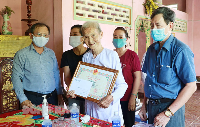 Phó chủ tịch HĐND tỉnh Huỳnh Quang Triệu (bìa trái) thăm, chúc thọ cụ Huỳnh Thị Kiên 90 tuổi xã Định Trung, huyện Bình Đại. Ảnh: T. Thảo