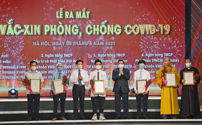 Thủ tướng Phạm Minh Chính trao giấy chứng nhận và hoa cảm ơn đại diện các tầng lớp nhân dân đóng góp vào Quỹ vaccine phòng chống COVID-19.