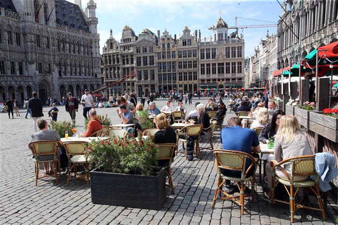 Người dân thưởng thức đồ uống bên ngoài một nhà hàng ở Brussels, Bỉ, ngày 9-5-2021. Ảnh: AFP/TTXVN