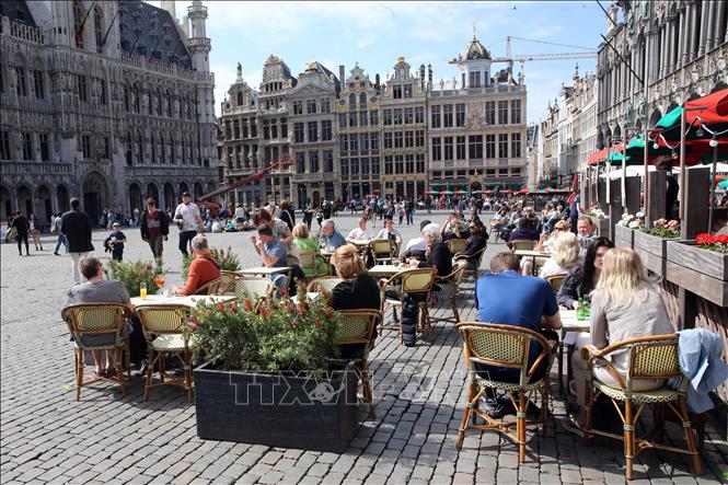 Người dân thưởng thức đồ uống bên ngoài một nhà hàng ở Brussels, Bỉ, ngày 9-5-2021. Ảnh: AFP/TTXVN