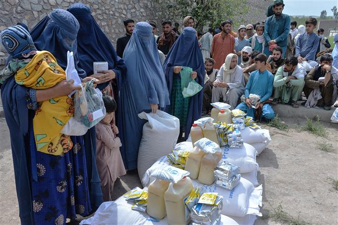 Người dân nhận lương thực cứu trợ tại Jalalabad, Afghanistan, ngày 20-4-2021. Ảnh: AFP/TTXVN