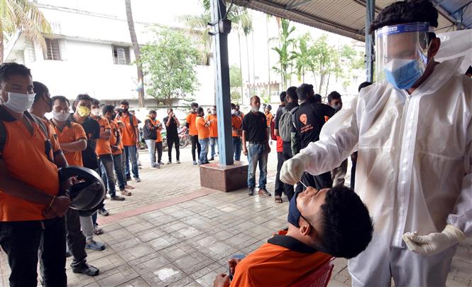 Mỹ chia sẻ 55 triệu liều vaccine cho các nước; Ấn Độ lập kỷ lục tiêm vaccine mỗi ngày Nhân viên y tế lấy mẫu xét nghiệm COVID-19 tại Guwahati, bang Assam, Ấn Độ. Ảnh: THX/TTXVN