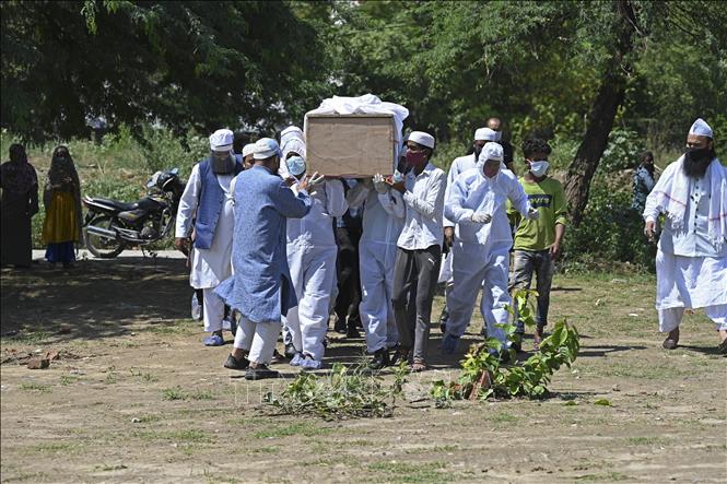 Chôn cất thi thể bệnh nhân COVID-19 tại một nghĩa địa ở New Delhi, Ấn Độ ngày 22-5-2021. Ảnh: AFP/TTXVN