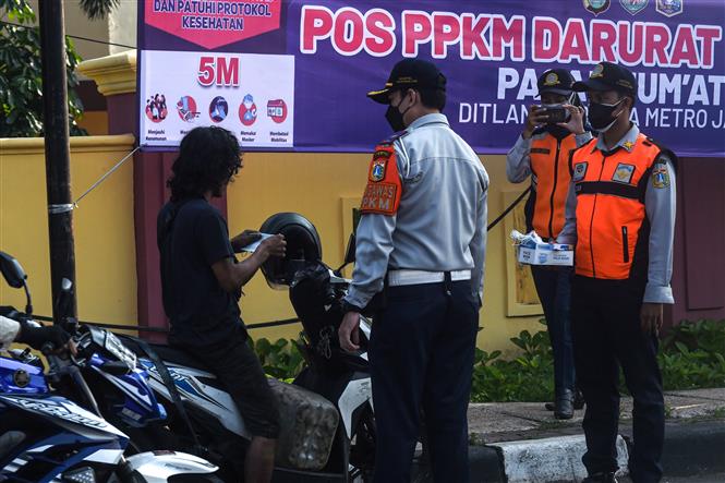 Nhân viên Bộ giao thông phát khẩu trang cho người dân để phòng tránh lây nhiễm COVID-19 tại Jakarta, Indonesia, ngày 3-7-2021. Ảnh: THX/TTXVN