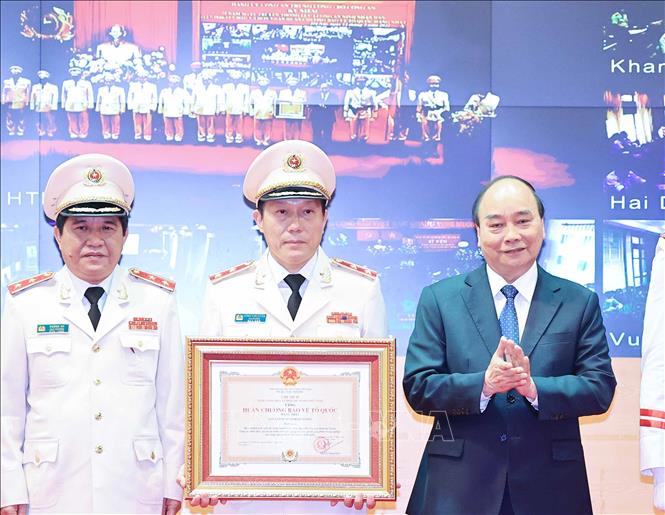 Thay mặt lãnh đạo Đảng, Nhà nước, Chủ tịch nước Nguyễn Xuân Phúc trao tặng Huân chương Bảo vệ Tổ quốc hạng Nhất cho lực lượng An ninh nhân dân. Ảnh: Thống Nhất/TTXVN