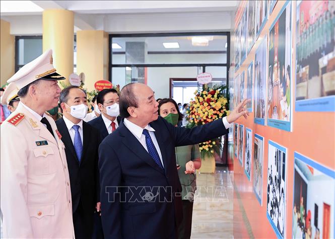 Chủ tịch nước Nguyễn Xuân Phúc tham quan trưng bày ảnh về các hoạt động của lực lượng An ninh nhân dân. Ảnh: Thống Nhất/TTXVN