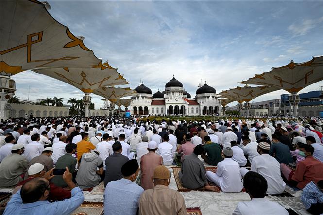 Indonesia ca lây nhiễm và tử vong mới cao nhất thế giới Các tín đồ Hồi giáo cầu nguyện bên ngoài một đền thờ ở Aceh, Indonesia để kỷ niệm lễ hiến sinh Eid al-Adha, ngày 20-7-2021. Ảnh: AFP/TTXVN