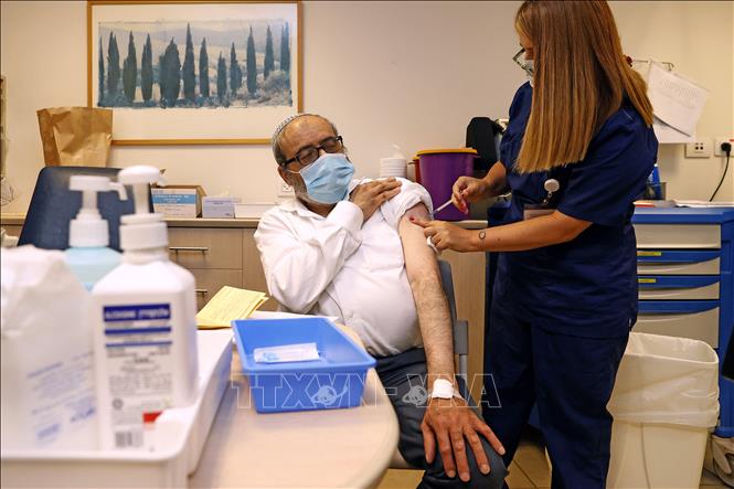 Các nước kêu gọi dân tiêm vaccine; Ca mắc, tử vong mới ở Indonesia cao nhất thế giới Nhân viên y tế tiêm vaccine COVID-19 cho người dân tại Tel Aviv, Israel. Ảnh: AFP/TTXVN