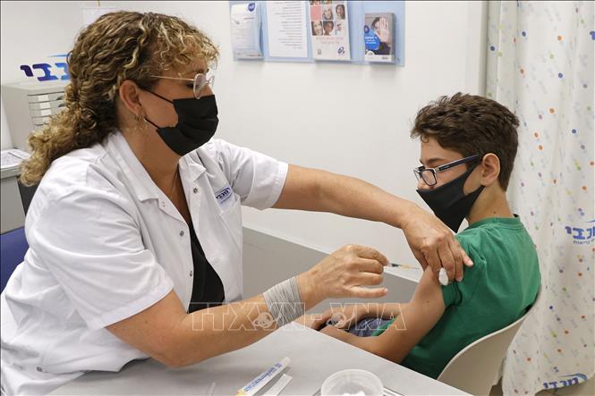 Các nước kêu gọi dân tiêm vaccine; Ca mắc, tử vong mới ở Indonesia cao nhất thế giới Nhân viên y tế tiêm vaccine COVID-19 của hãng Pfizer/BioNTech cho một em nhỏ 12 tuổi tại Tel Aviv, Israel ngày 6-6-2021. Ảnh: AFP/TTXVN
