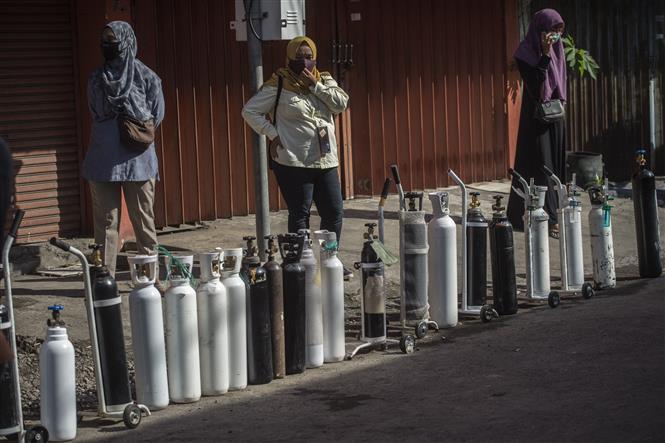 Người dân xếp hàng chờ bơm oxy y tế phục vụ điều trị cho bệnh nhân COVID-19 tại thành phố Surabaya, Đông Java, Indonesia, ngày 15-7-2021. Ảnh: AFP/TTXVN