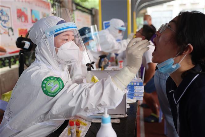 Mỹ ghi nhận gần 100.000 ca mắc mới; WHO khuyến cáo dừng tiêm mũi vaccine thứ 3 Nhân viên y tế lấy mẫu xét nghiệm COVID-19 cho người dân tại Phúc Kiến, Trung Quốc, ngày 2-8-2021. Ảnh: THX/TTXVN