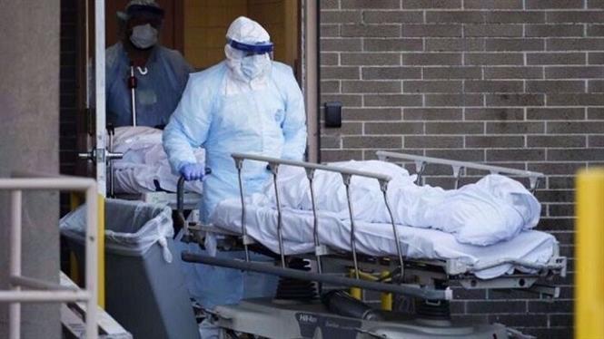 Mỹ lại trên 100.000 ca mắc mới/ngày; Trung Quốc dịch bệnh leo thang mạnh Nhân viên y tế chuyển thi thể bệnh nhân tử vong do COVID-19 tại Tehran, Iran. Ảnh: IRNA/ TTXVN