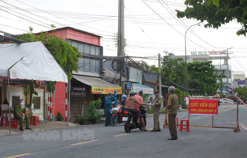 Hưởng ứng lời kêu gọi của Đảng và Nhà nước “chống dịch như chống giặc” Người dân chấp hành các quy định khi đi qua các chốt kiểm soát. Ảnh: N. Thạch