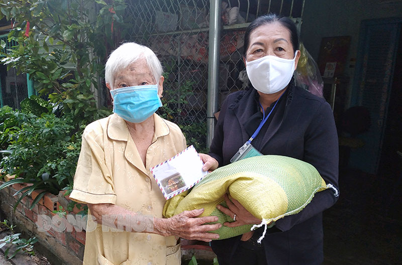 Chủ tịch Hội Cựu chiến binh xã Mỹ Thạnh An Nguyễn Thị Bạch Tuyết (bên phải) trao quà hỗ trợ cho gia đình khó khăn do dịch Covid-19.