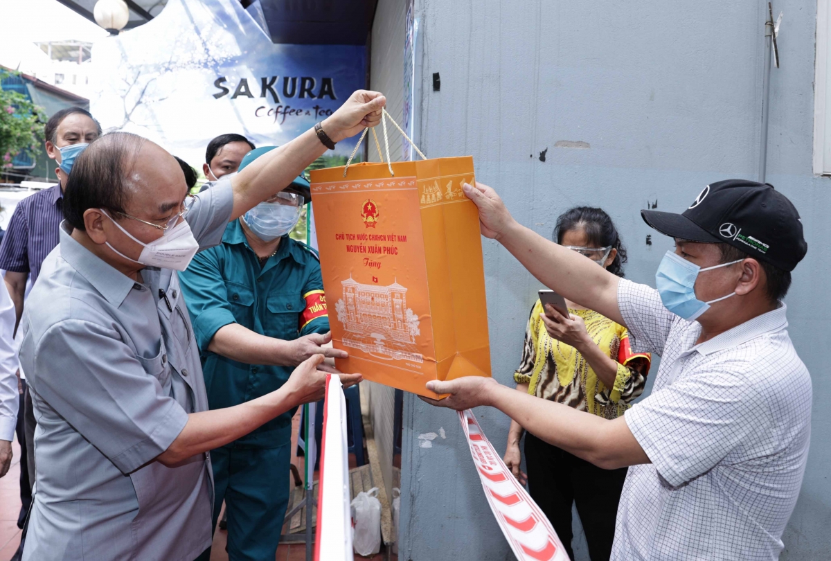 Chủ tịch nước động viên lực lượng tuyến đầu và nhân dân Thủ đô phòng, chống dịch COVID-19 Chủ tịch nước Nguyễn Xuân Phúc tặng quà người dân ở nơi thực hiện giãn cách xã hội.