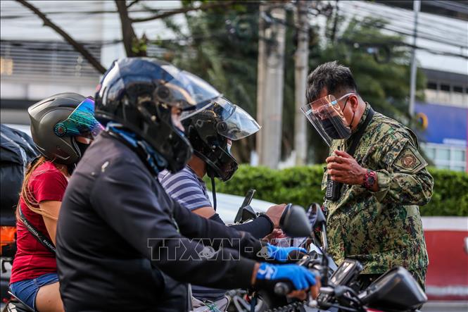 Cảnh sát kiểm tra người lưu thông nhằm đảm bảo người dân tuân thủ quy định phòng chống dịch COVID-19 tại một chốt kiểm soát ở thành phố Quezon, Philippines ngày 6-8-2021. Ảnh: THX/TTXVN