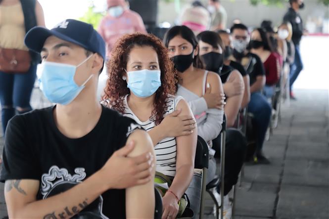 Người dân ngồi chờ theo dõi sau khi tiêm vaccine ngừa COVID-19 tại Nezahualcoyotl, Mexico ngày 19-8-2021. Ảnh: THX/TTXVN