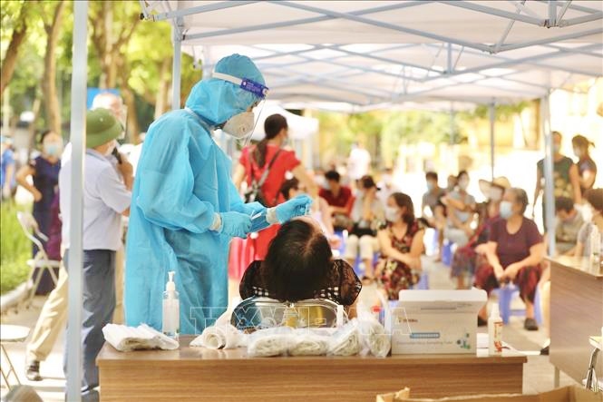 Lấy mẫu xét nghiệm COVID-19 cho người dân ở khu vực có nguy cơ cao. Ảnh: TTXVN